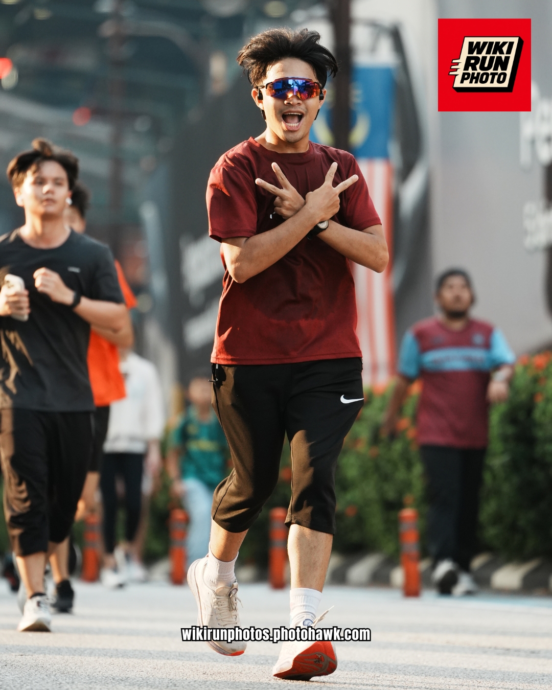 Runner in maroon greeting the camera.