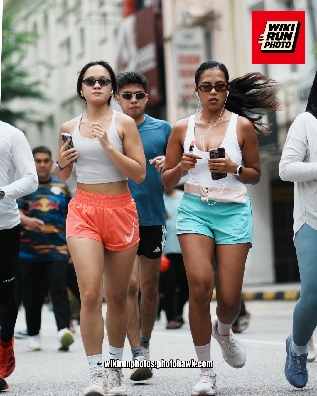Two runners in coral and turquoise shorts.